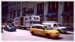Classic Moving & Storage crew loading the truck on a busy city street