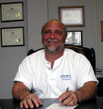 Jeff Brito, owner and operator, standing with Classic Moving & Storage equipment